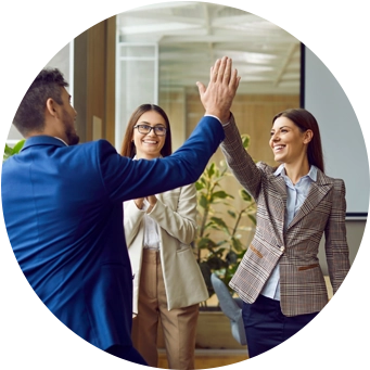 Bir ofis ortamında başarılı bir ortaklığı kutlayan bir iş ekibi, yüksek beş hareketi yapıyor.